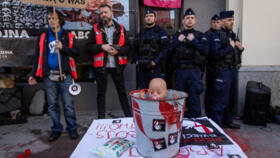 A bucket with a doll representing a newborn baby covered in red paint is displayed as pro-life activists protest in front of Poland's first activist-run abortion consultation point, on March 8, 2025.