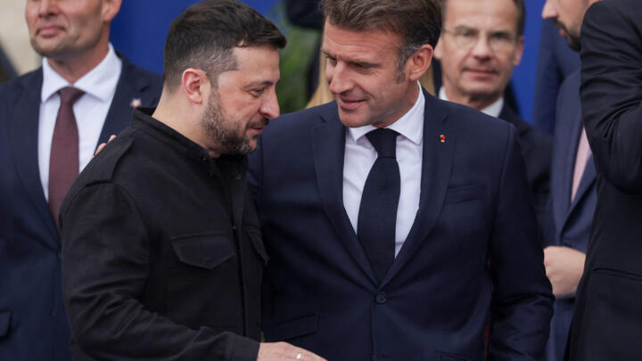 Ukraine's President Volodymyr Zelensky (L) speaks with France's President Emmanuel Macron during the European Political Community summit, in Tirana on May 16, 2025.