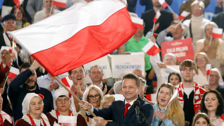 Rafal Trzaskowski, Presidential candidate, Warsaw's mayor and member of Poland's ruling Civic Coalition party, waves the Polish flag as he speaks to supporters after first exit polls following Preside