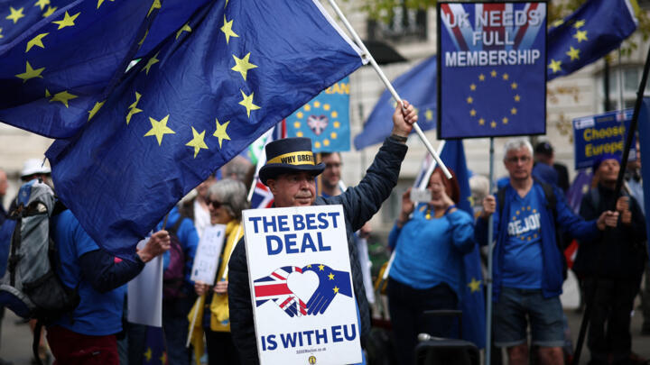 Anti-Brexit demonstrator Steve Bray and fellow pro EU activists wave flags as they protest near Lancaster House, the venue of the UK-EU Summit, in London on May 19, 2025.