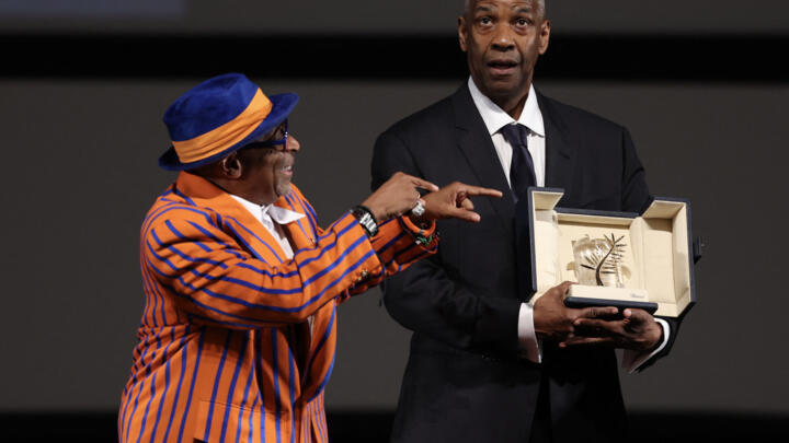 L'acteur américain Denzel Washington reçoit la Palme d'or d'honneur des mains du réalisateur et producteur américain Spike Lee avant la projection du film "Highest 2 Lowest" lors de la 78e édition du