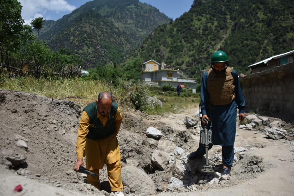 A civil defence team searches for unexploded ordnance near Jura village