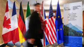 A man walk past the G7 members flags at the Manoir Richelieu before the G7 Foreign Ministers summit in La Malbaie, Quebec, Canada March 12, 2025.