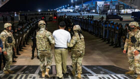 US military personnel escort an alleged gang member who was deported by the US along with others the US alleges are members of the Venezuelan gang Tren de Aragua and the MS-13 gang to be imprisoned.