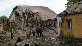 Resident Vadym Tsybenko, 22-year-old, stands by his house and that  of his neighbours, heavily damaged by a Russian drone strike, outside of Kyiv, Ukraine May 18, 2025.